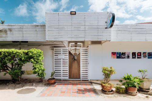 a white house with white shutters and potted plants at Ibiza House Phi Phi in Phi Phi Don