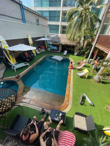 a group of people laying on chairs by a swimming pool at Smokers Resort in Pattaya South