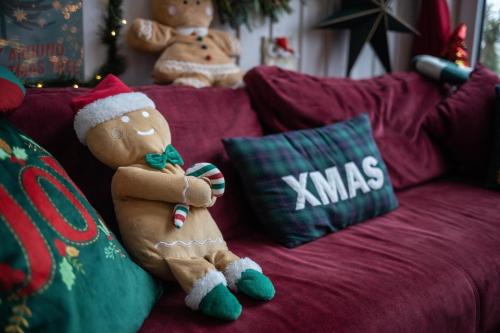 a teddy bear wearing a santa hat sitting on a couch at Czereśniowe Wzgórze Sandomierz jakuzzi in Sandomierz