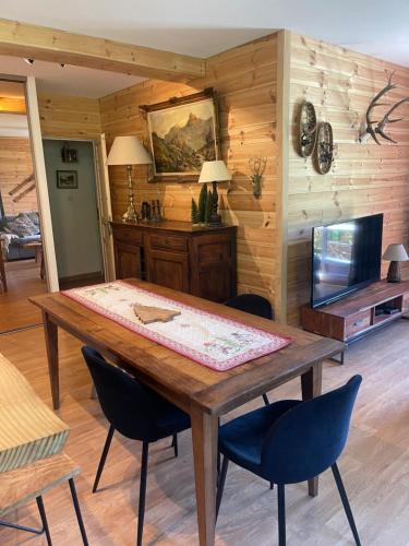 une salle à manger avec une table et des chaises en bois dans l'établissement Le Petit Torrent, à Pra-Loup