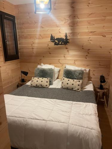 - une chambre avec un lit et un mur en bois dans l'établissement Le Petit Torrent, à Pra-Loup
