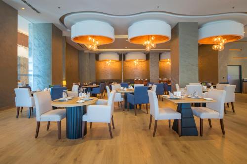 a dining room with tables and chairs and chandeliers at Crowne Plaza Kayseri by IHG in Kayseri