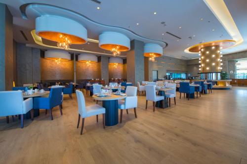 a restaurant with tables and chairs and blue chairs at Crowne Plaza Kayseri by IHG in Kayseri
