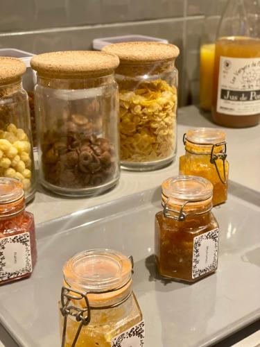 Un grupo de frascos de mermelada en un estante con miel. en Hôtel Saint-Roch, Saint-Ybard, en Saint-Ybard