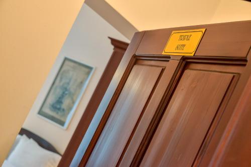 a yellow sign on top of a wooden door at An der Holztreppe in Sighişoara