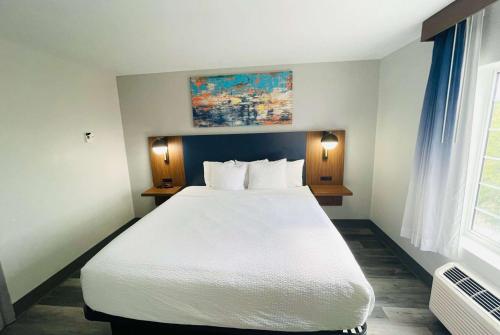 a bedroom with a large white bed and a window at La Quinta by Wyndham Birmingham Homewood in Birmingham