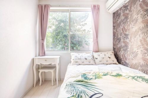 a small bedroom with a bed and a window at Dream蒲田 in Tokyo