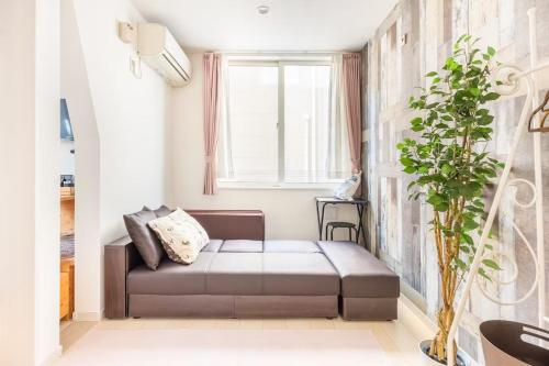 a living room with a couch and a window at Dream蒲田 in Tokyo