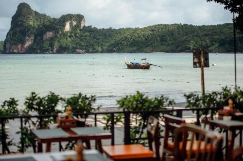 a boat in a body of water with a mountain at Ibiza House Phi Phi in Phi Phi Don
