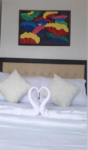 two swans making a heart shape on a bed at Cozy Staycation in Manila