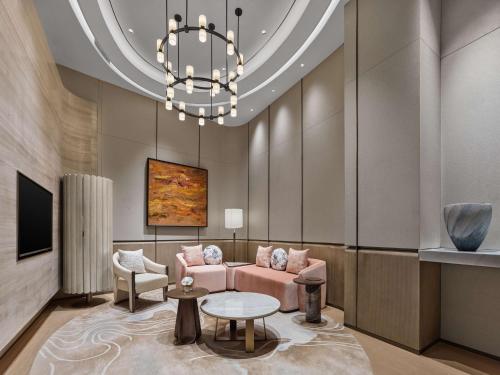 a living room with a pink couch and a chandelier at Doubletree By Hilton Chengdu Xinglong Lake in Chengdu