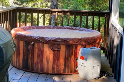 a large wooden tub sitting on a deck at Beautiful Renovated Cozy Forest Home with Hot Tub in Crestline in Crestline