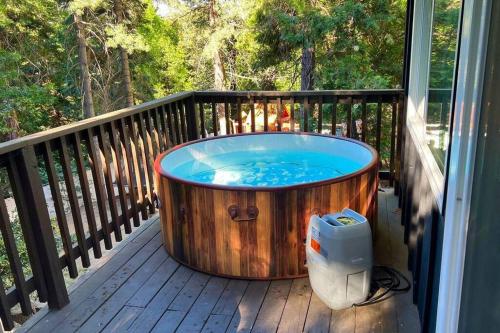 a hot tub sitting on a deck on a porch at Beautiful Renovated Cozy Forest Home with Hot Tub in Crestline in Crestline