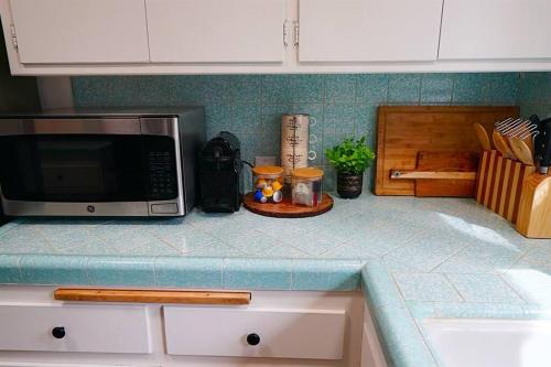 a kitchen counter with a microwave on top of it at Beautiful Renovated Cozy Forest Home with Hot Tub in Crestline in Crestline