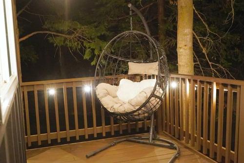 a swing chair sitting on a porch at night at Beautiful Renovated Cozy Forest Home with Hot Tub in Crestline in Crestline