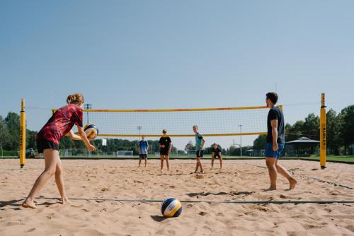 a group of people playing volleyball on a beach at Sportschule Oberhaching in Oberhaching