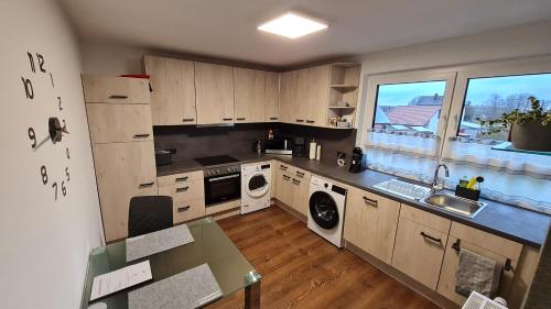 a kitchen with wooden cabinets and a sink and a window at Ferienwohnung Helfensteinblick in Calden