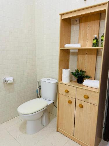 a bathroom with a toilet and a wooden cabinet at Les HOTELS TALHAYA, NOUAKCHOTT in Nouakchott