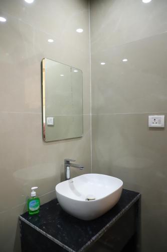 a bathroom with a sink and a mirror on a counter at Dhurva Hotel and Resort in Naugaon