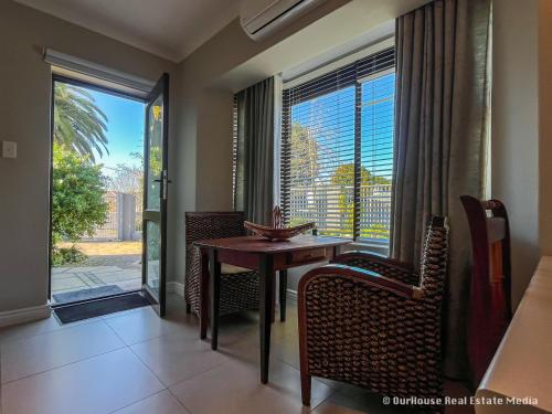 a dining room with a table and chairs and a window at 7Pillars Shiraz in Durbanville
