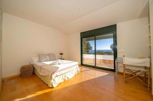 une chambre avec un lit, un bureau et une fenêtre dans l'établissement Villa Les Oliveres - Lux Houses Experience, à Lloret de Mar