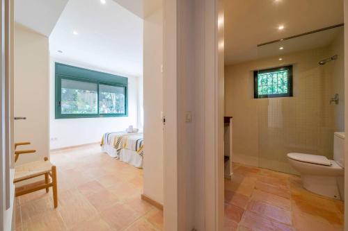 - une salle de bains avec toilettes et un lit dans une chambre dans l'établissement Villa Les Oliveres - Lux Houses Experience, à Lloret de Mar