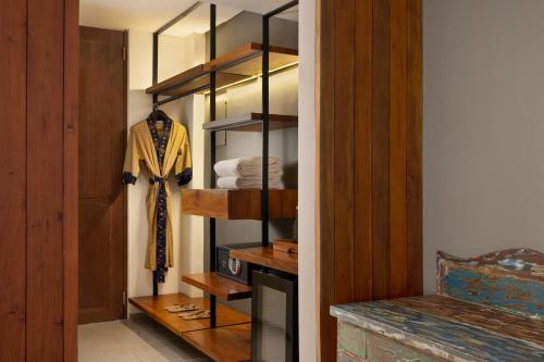 a room with a closet with a suit on a shelf at Dialoog Seminyak in Seminyak