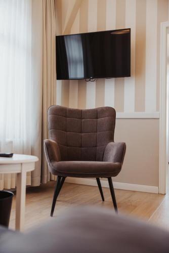 a brown chair sitting in a room with a tv at Villa Strandperle IV Jahreszeiten Kühlungsborn in Kühlungsborn