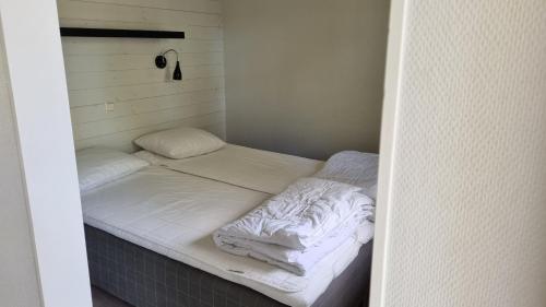 a small room with two beds with white sheets at Rättviks Golfby in Rättvik