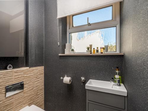 a bathroom with a sink and a window at Cosy Home w Stylish Interior - PassTheKeys in Watford
