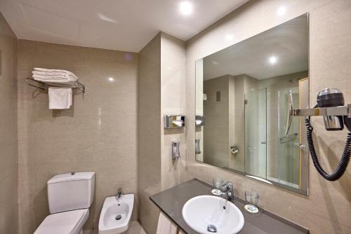a bathroom with a sink and a toilet and a mirror at Civis Jaime I in Castellón de la Plana