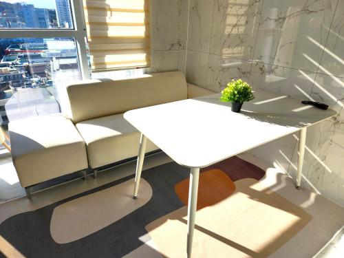 a white table and a couch in a room at Majestic Seoul Stay Central in Seoul