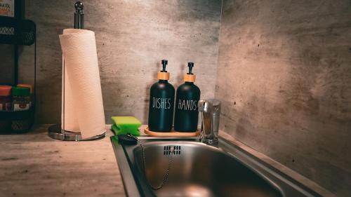 two bottles of wine sitting on top of a sink at NOX Business Apartments in Tuttlingen