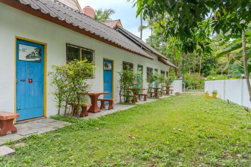 Good Night Long Beach Bungalow في كو لانتا: مبنى ذو أبواب زرقاء ومقاعد في فناء