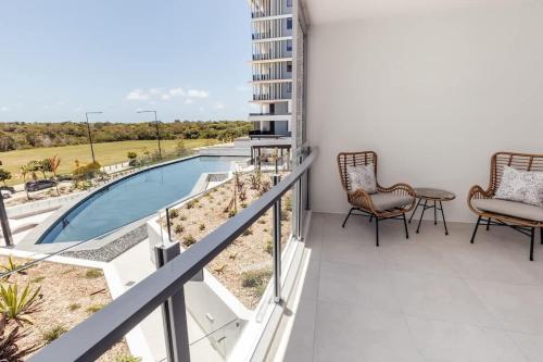 a balcony with chairs and a swimming pool at Azzure Bliss at Bokarina Beach in Kawana Waters