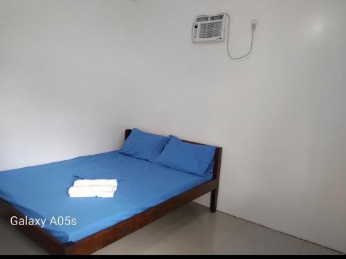 un petit lit avec des draps et des serviettes bleus dessus dans l'établissement Francis Home Stay Port Barton bonifacio street, à San Vicente