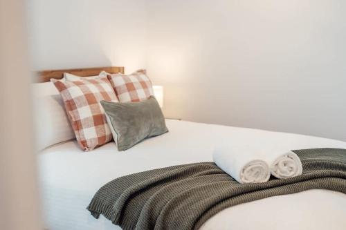 a white bed with pillows and towels on it at Azzure Bliss at Bokarina Beach in Kawana Waters