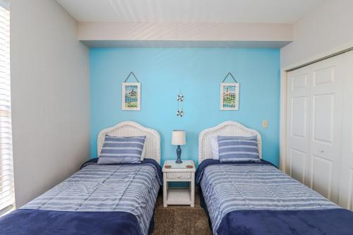 twee bedden in een kamer met blauwe muren bij Seaside at Anastasia D205 in St. Augustine