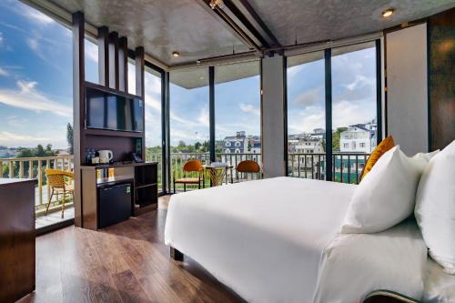 a bedroom with a large bed and a balcony at Phuc Hai Hotel Da Lat in Da Lat