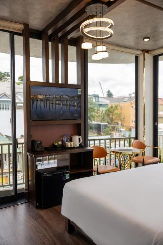 a bedroom with a bed and a flat screen tv at Phuc Hai Hotel Da Lat in Da Lat