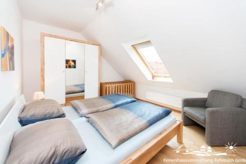 a bedroom with a bed and a couch and a chair at 53 Ferienwohnung im Fritz-Bleyl-Weg 14 OG rechts in Burg auf Fehmarn