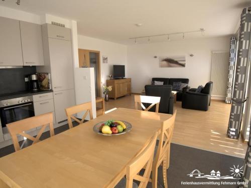 a kitchen and living room with a bowl of fruit on a table at 51 Ferienwohnung im Fritz-Bleyl-Weg 14 EG rechts in Burg auf Fehmarn