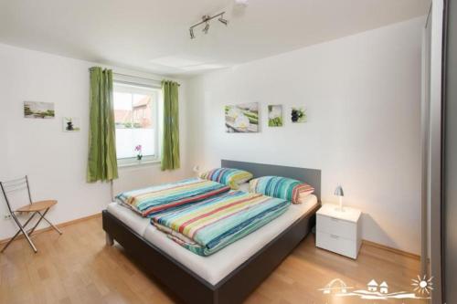 a bedroom with a bed with colorful pillows at 51 Ferienwohnung im Fritz-Bleyl-Weg 14 EG rechts in Burg auf Fehmarn