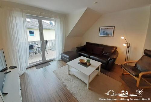 a living room with a couch and a table at 44 Apartment Sunshine Birkenweg 1c OG in Burg auf Fehmarn