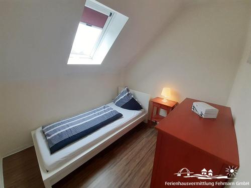 a small bedroom with a bed and a window at 44 Apartment Sunshine Birkenweg 1c OG in Burg auf Fehmarn