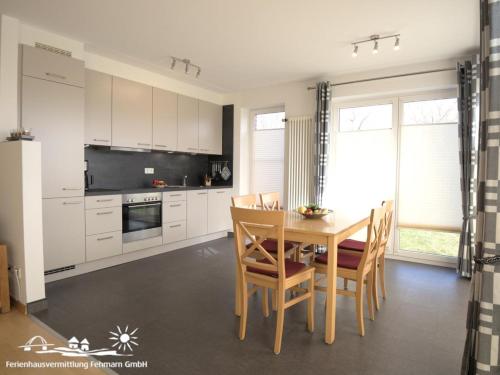 a kitchen with a wooden table and a dining room at 52 Ferienwohnung im Fritz-Bleyl-Weg 14 EG links in Burg auf Fehmarn