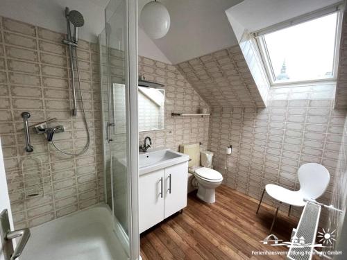 Un baño con inodoro, lavabo y ducha. en 46 Ferienwohnung Burg, en Burg auf Fehmarn