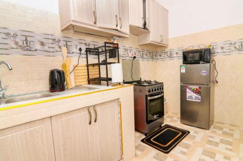 a kitchen with a stove and a refrigerator at Jay Homes - Naiva Heights in Naivasha