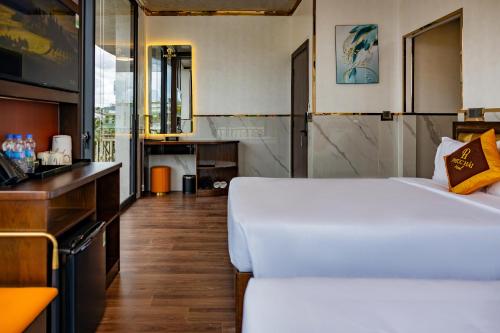 a bedroom with a large white bed and a kitchen at Phuc Hai Hotel Da Lat in Da Lat