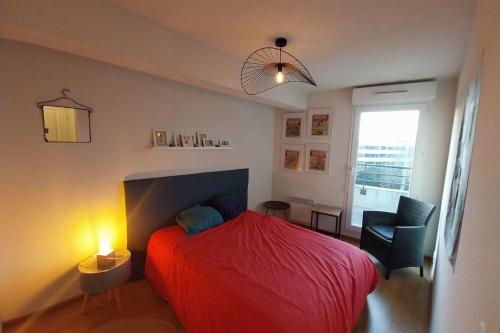 - une chambre avec un lit rouge et une chaise dans l'établissement Charming T3 with balcony near beach, à Vannes